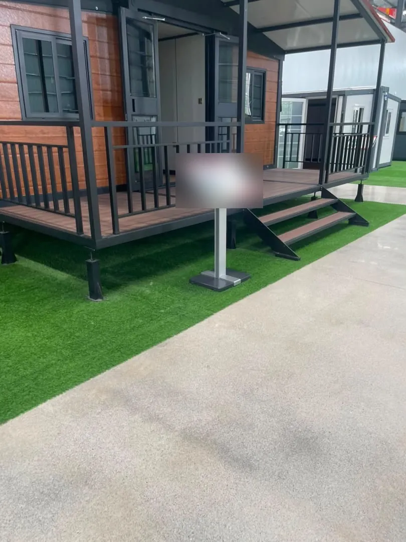 Finished house with a wooden deck, steps and an information stand with the text blurred